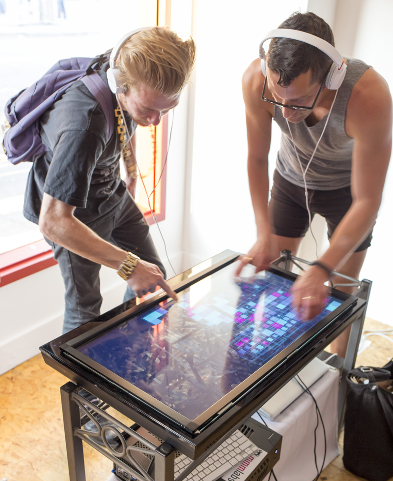 two guys using a touchscreen to interact with the artwork Beckon